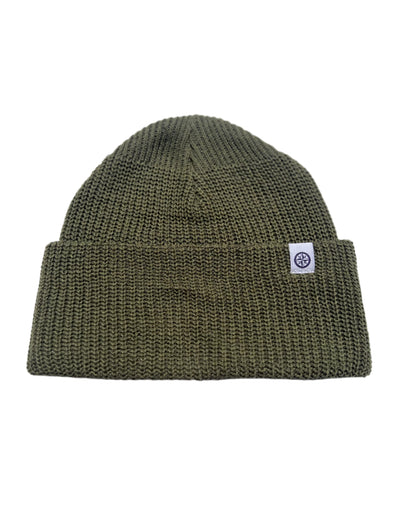 Green knit beanie with a logo tag on a white  background
