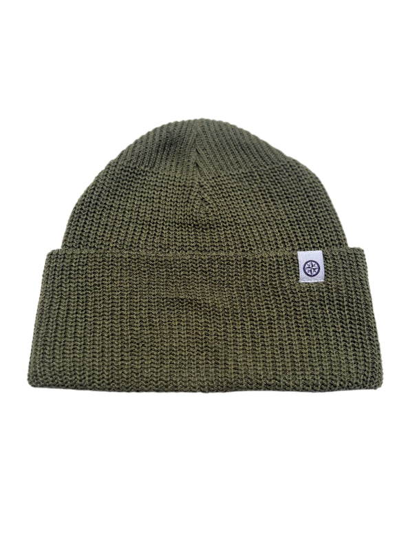Green knit beanie with a logo tag on a white  background