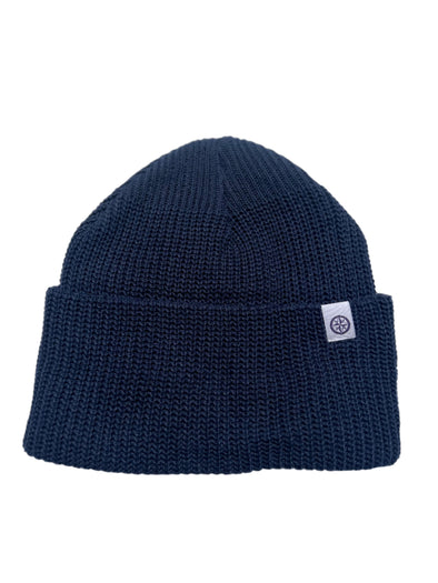 Navy blue beanie with a white logo tag on a white background