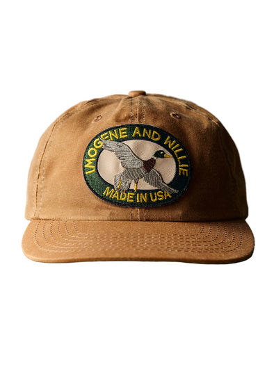 Brown cap with a logo and text on a rustic wooden surface